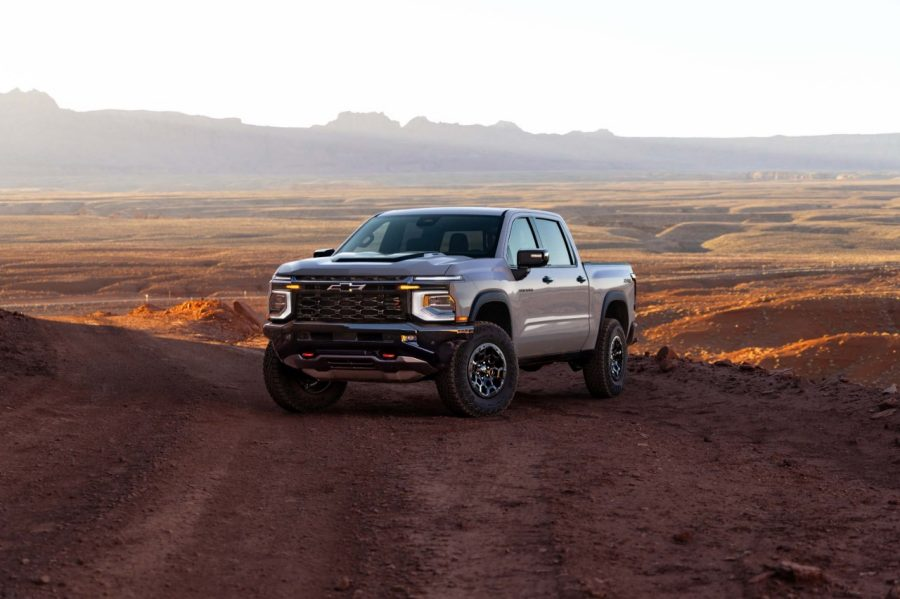 Gray Chevy Truck parked on desert road with moutains in the background